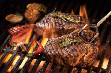 Beef steaks on the grill with flames