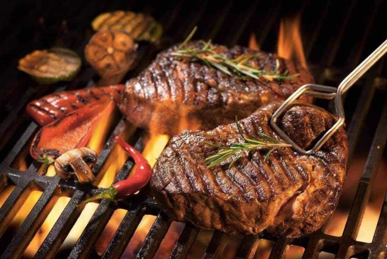 Beef steaks on the grill with flames